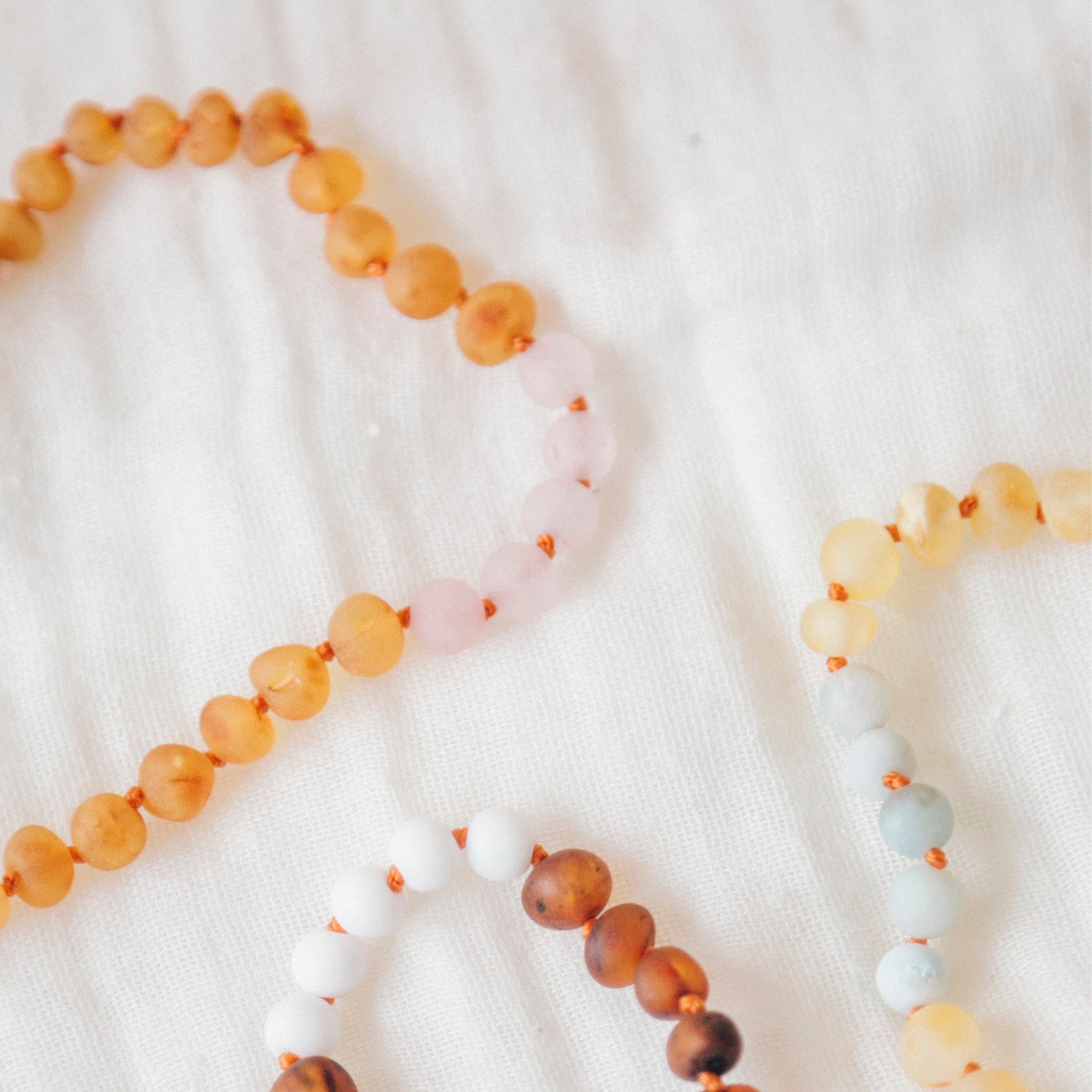 Collier pour bébé en ambre et quartz rose miel