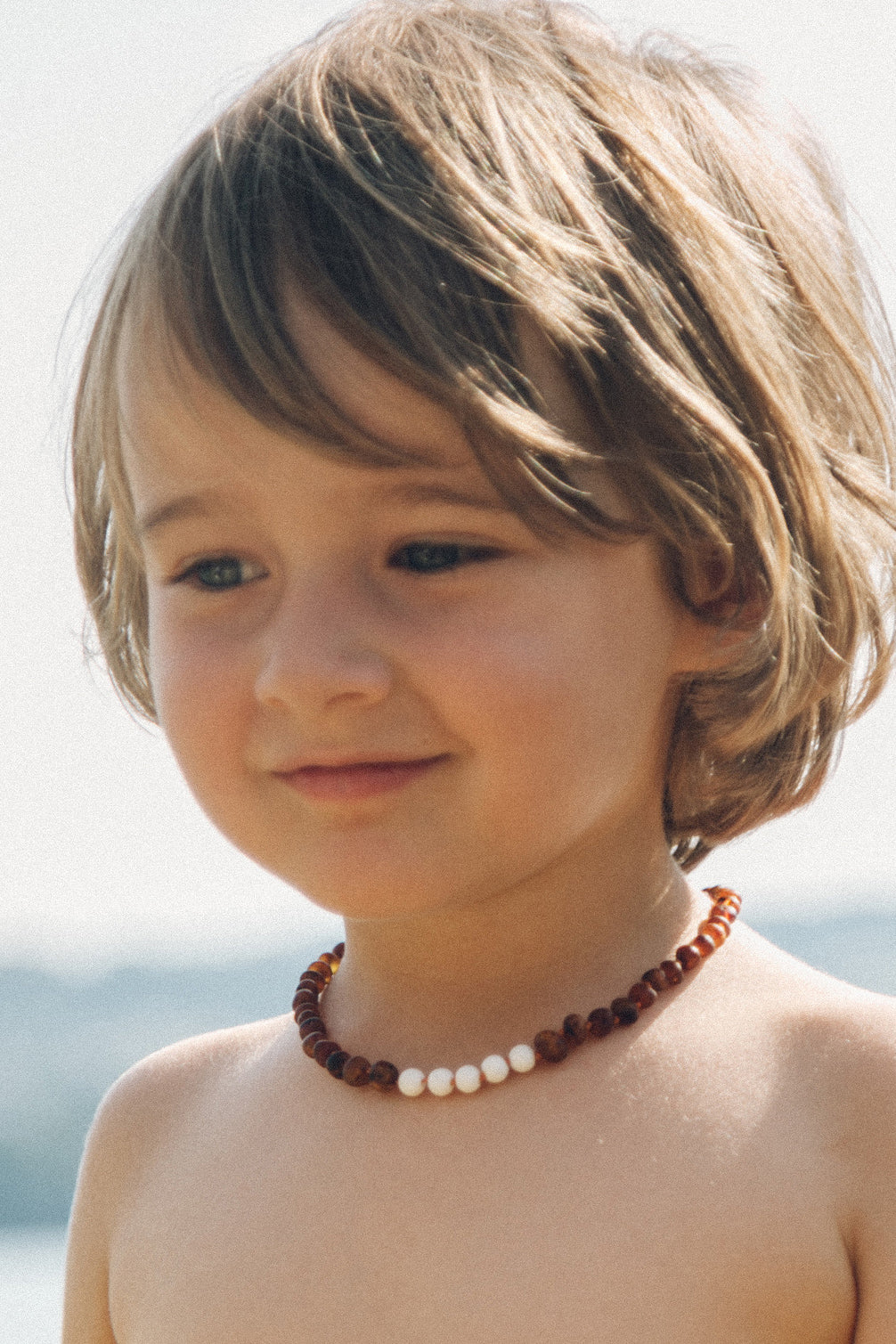 Collier pour bébé en ambre, châtaigne et onyx blanc